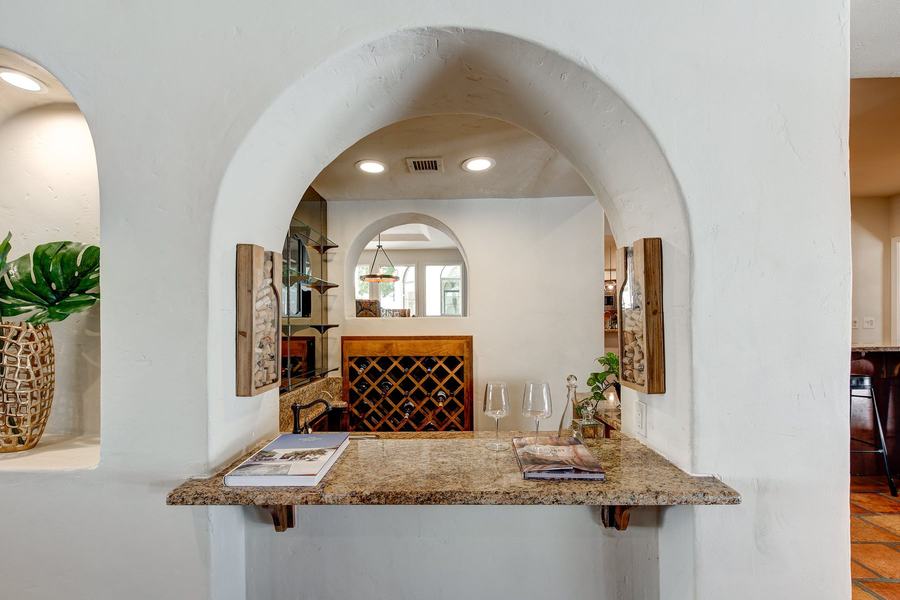 Charming Arched Wine Bar with Granite Counter & Built-In Wine Rack